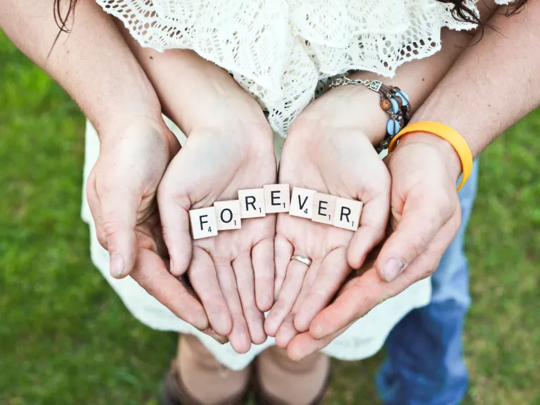 A couple holding tiles spelling FOREVER in their hands